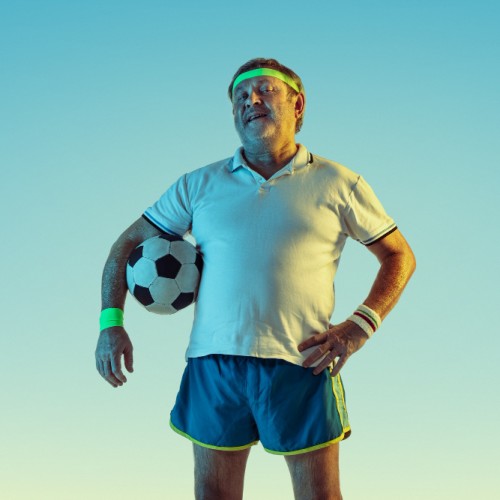 senior-man-playing-football-in-sportwear-on-gradient-background-and-neon-light.jpg